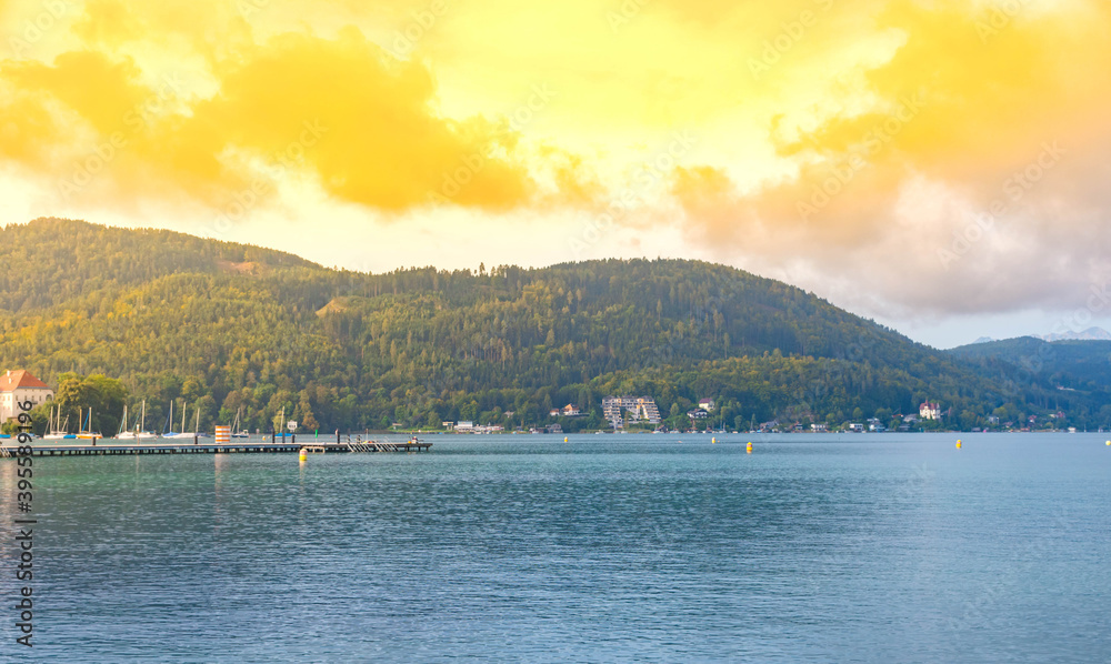 View of the alpine Lake Worthersee, famous tourist attraction for swimming, boating, sunbathing and walking, in Carinthia region, Austria View of the alpine Lake Worthersee, famous tourist attraction for swimming, boating, sunbathing and walking, in Carinthia region, Austria