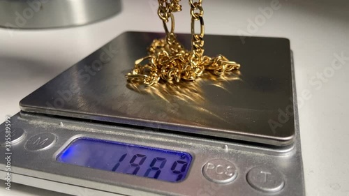 Gold scrap pile chains and bangle  jewelry on weight scale at pawn shop for money 