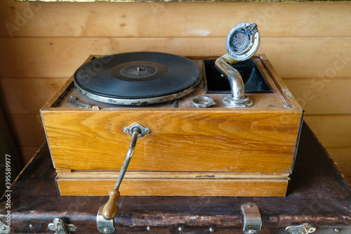 Old vintage record player vinyl records gramophone (phonograph) on a wooden background.