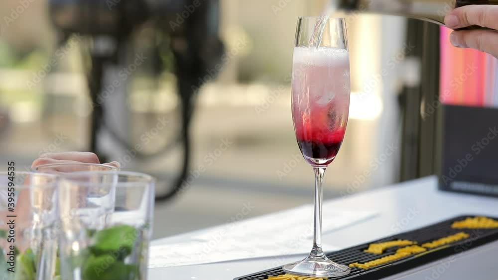 Close up, the bartender pours champagne into glasses with orange slices, and foam forms. The waiter prepares drinks for the guests. Close up, the bartender pours champagne into glasses with orange slices, and foam forms. The waiter prepares drinks for the guests.