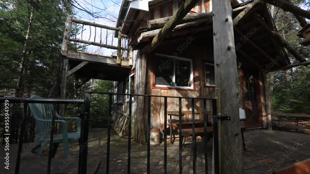 Camera slowly approaching the porch of a DIY, hand made mini house in the forest, then lifting to fly over the parapet. Adventure living into the wild Camera slowly approaching the porch of a DIY, hand made mini house in the forest, then lifting to fly over the parapet. Adventure living into the wild
