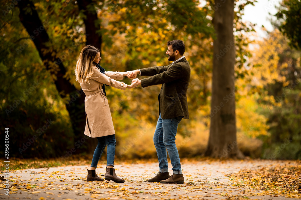 Fototapeta premium Young couple having fun in the autumn park