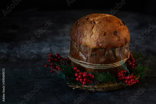 Easter bread. Christmas panettone, on a mistletoe wreath in Background with dark