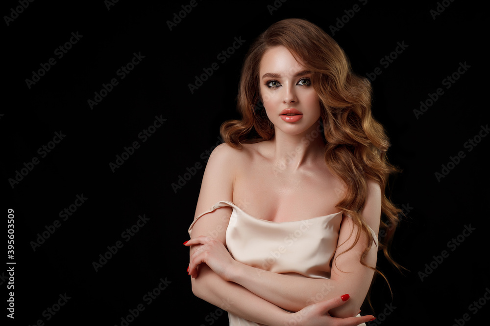 Naklejka premium Beauty portrait of elegant young woman. Glamour makeup. Face of the beautiful woman with long brown curly hair posing at studio over dark background. Sensual portrait.