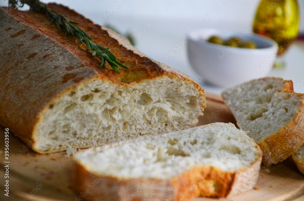Sliced bread Ciabatta and rosemary on wooden on white background Sliced bread Ciabatta and rosemary on wooden on white background