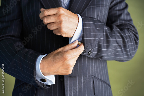 Midsection Of Man In Suit Buttoning Cuff Sleeves