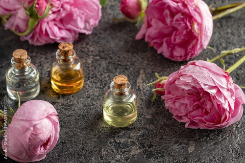 A bottle of essential oil with rose de mai flowers photo