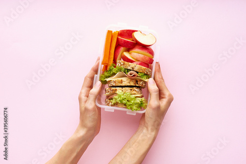 Woman holding lunch box with healthy nutritious meal