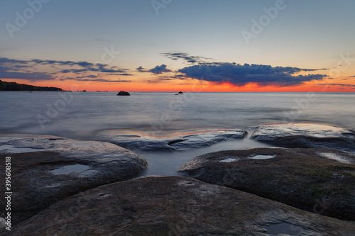 Beautiful colorful sunset over sea and rocks. Baltic sea. Estonia. Long exposure.