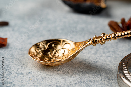 Close up of golden metal spoon on grey surface