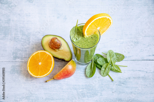 A green smoothie with avocado, spinach, orange and pears photo