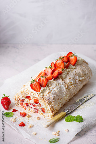 Meringue roulade with fresh whipped cream and strawberries