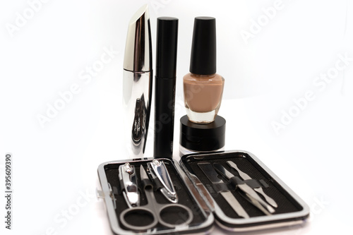 Tools of a manicure set, mascara lipstick, eyebrow shadow and nail polish isolated on white background