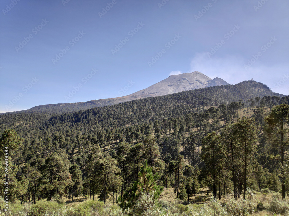 Fototapeta premium Vista del volcán Iztaccíhuatl, La Mujer Dormida, desde el Paso de Cortés en Puebla, México con un cielo azul como fondo. Recorte horizontal.