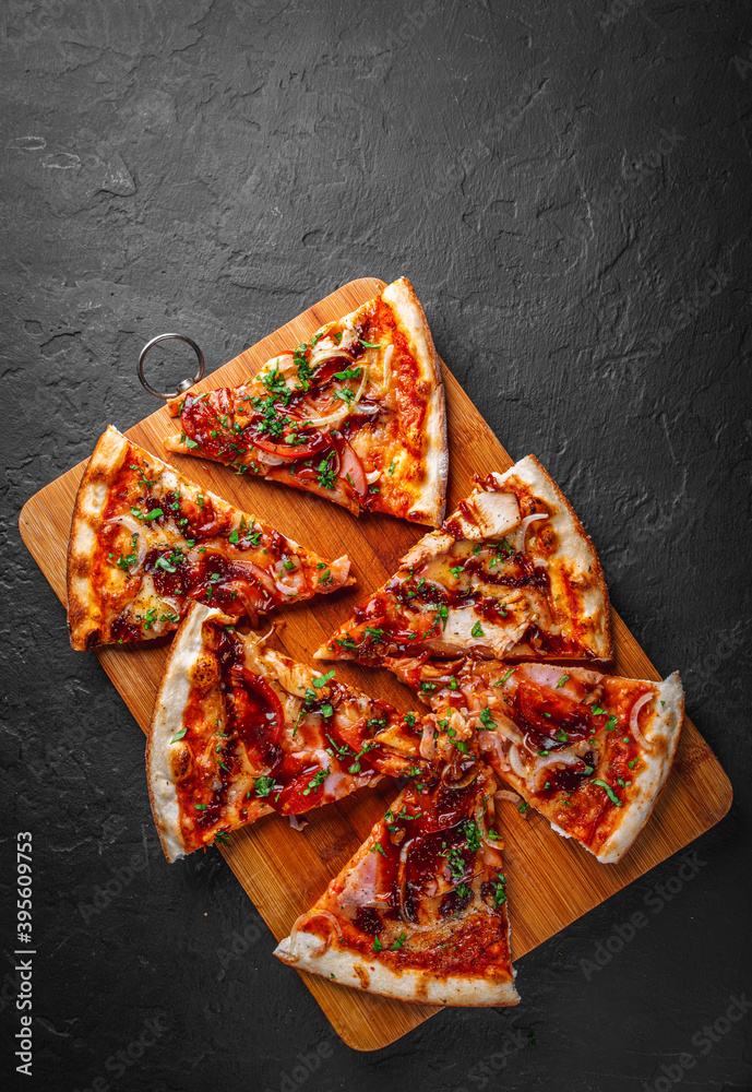 slice of Pizza with chicken and barbeque sauce. Italian pizza on Dark grey black slate background