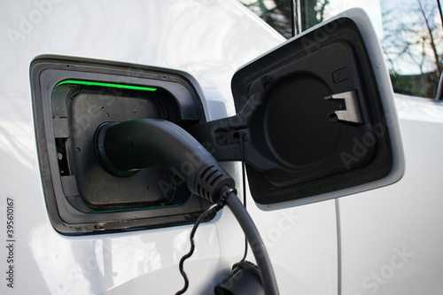 Electric Car Charging at Home with green light on charger 