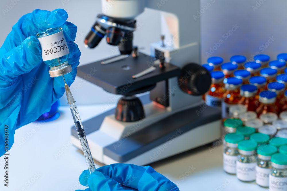 Doctor hands in blue gloves holding Sars-cov-2 vaccine vial Doctor hands in blue gloves holding Sars-cov-2 vaccine vial