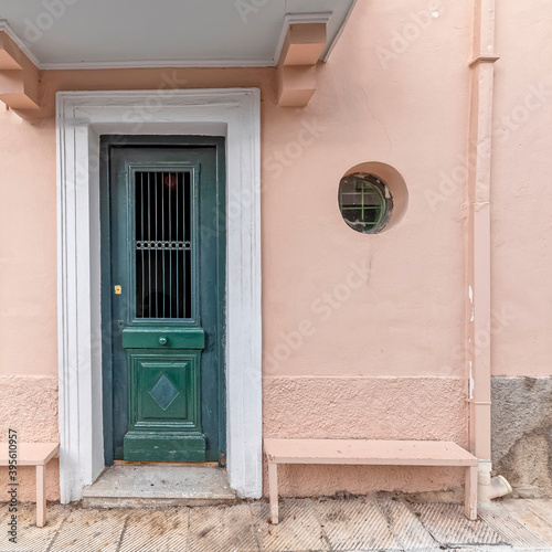 Contemporary house entrance green painted door on pink wall, Athens Greece.