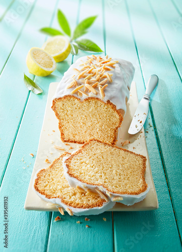 Lemon cake with icing and almond nibs, sliced photo