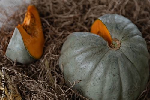 Pumpkin cut into dry straw and wood in the background. Rustic style. 