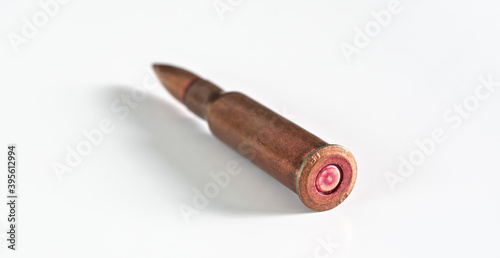 Copper machine gun bullet laying - isolated on white background