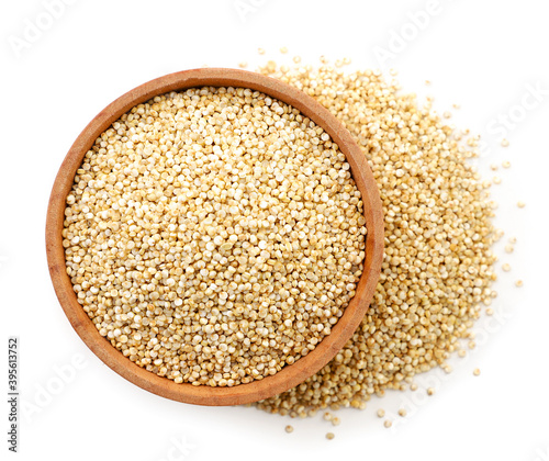 Quinoa in a wooden plate on a white background, isolated. The view from top