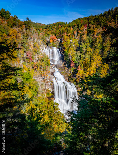 Evergreen trees frame the fall foliage and Whitewater falls in NC