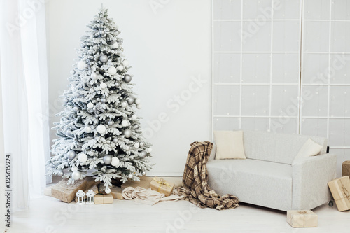 Home interior. A room with a beautiful snowy Christmas tree and gifts under this tree.