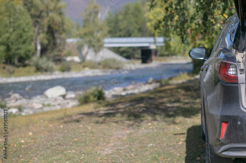 Gray Car close-up standing on the bank of picturesque mountain lake