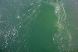 Abstract liquid mixing view from top. Green and white water mix