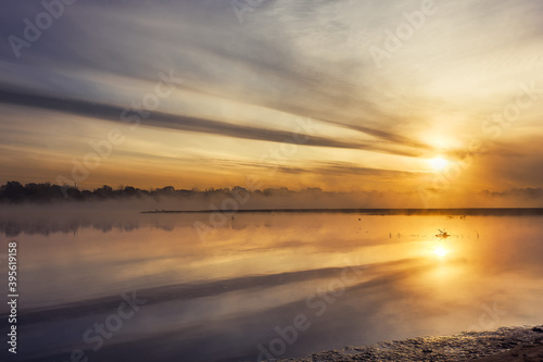 Golder sunrise over calm foggy river © Michał Kozera