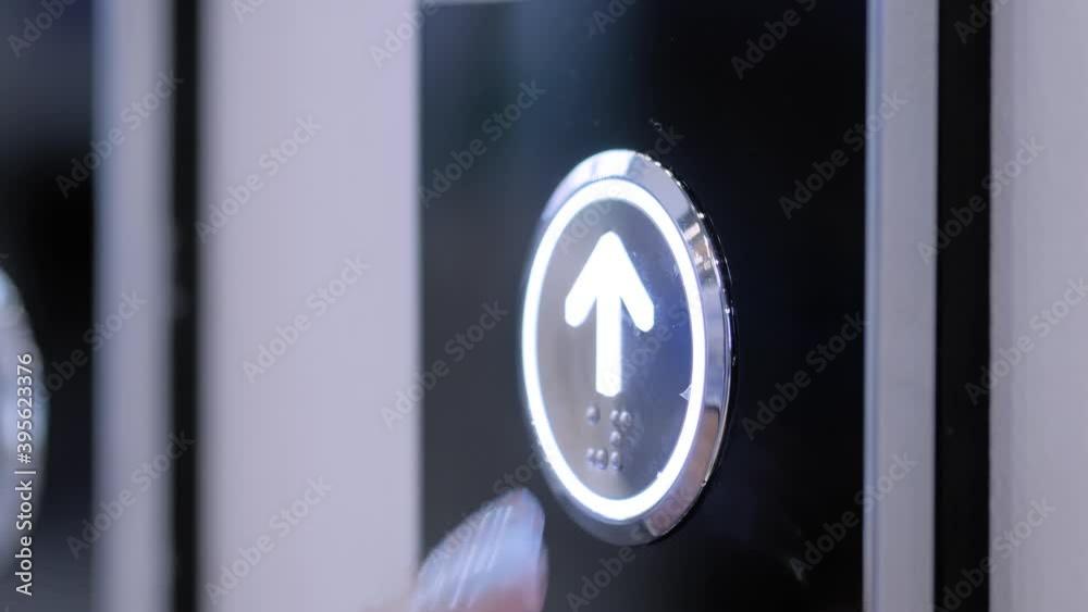Slow motion: woman finger pressing elevator up button on lift control panel at mall, hotel or business center - close up view. Technology, moving up, progress, growth and success concept