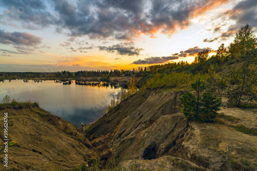 Autumn landscape with beautiful clouds over the lake at sunset. © amarinchenko106