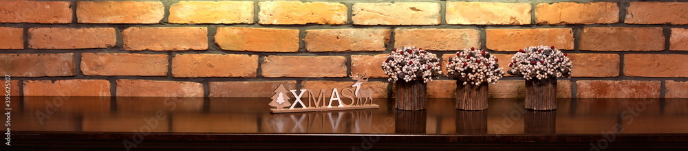 Xmas inscription and Christmas decorations on the background of an old brick wall.

 - obrazy, fototapety, plakaty 