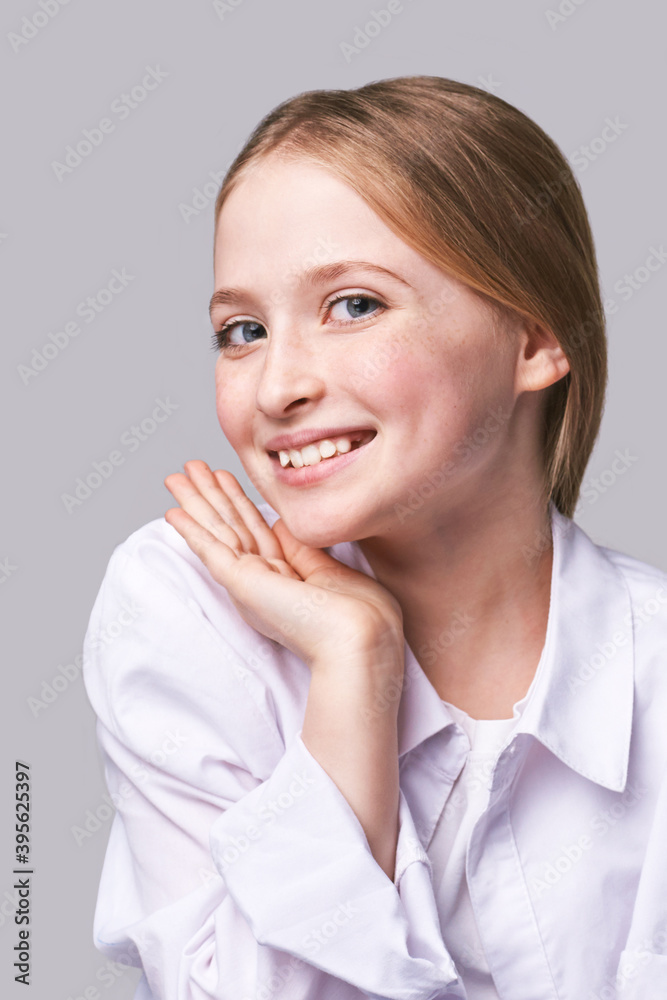Beauty girl portrait. Young woman. Hand near nead. Face massage concept. White shirt. Cosmetology facelift laser. Medical rejuvenation scrub. Skin care hygiene. Grey background. Smiling Beauty girl portrait. Young woman. Hand near nead. Face massage concept. White shirt. Cosmetology facelift laser. Medical rejuvenation scrub. Skin care hygiene. Grey background. Smiling