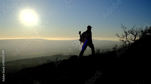 Silhouette of Man go hiking and look at the beautiful sunset view on mountain