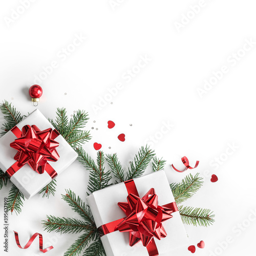 Merry Christmas card made of fir branches, gift boxes, red decoration, sparkles and confetti on white background. Xmas and New Year holiday, bokeh, light. Flat lay, top view