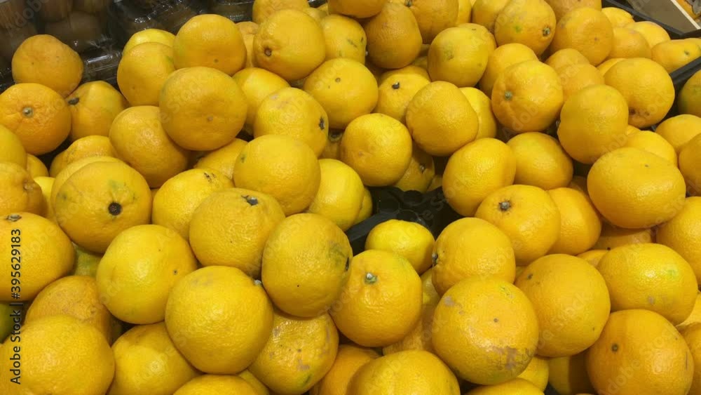 Yellow oranges are on sale in supermarket, close up view as a background Yellow oranges are on sale in supermarket, close up view as a background