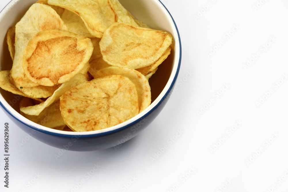 Salty Potato chips in a bowl isolated on white background.