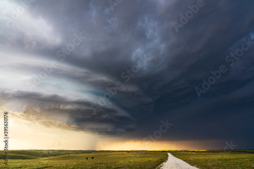 Canvas Print Dramatic storm clouds and dark sky over a dirt road