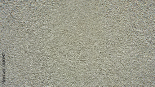 Pale yellow concrete wall. Interesting abstract background with a construction concept. Decorative textured plaster of the house wall. Outside surface finish at home.