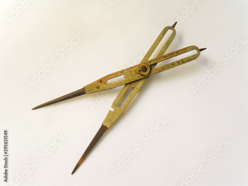 Old brass reduction compass or proportional scale divider. Geometry tool used to scale designs. photo