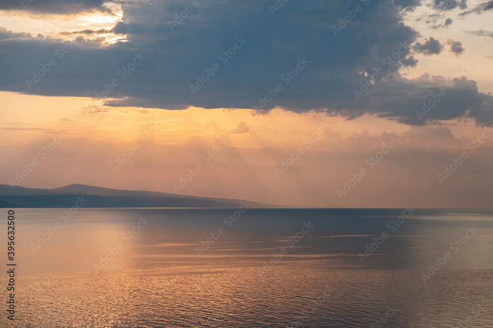 Sunset sea landscape. Beautiful sunset in Croatia. Sunbeams and clouds