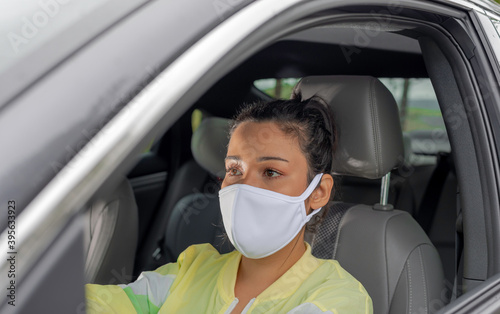 Brazilian woman wearing protective mask inside the car