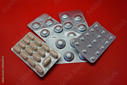 Blister packs of pills on red background