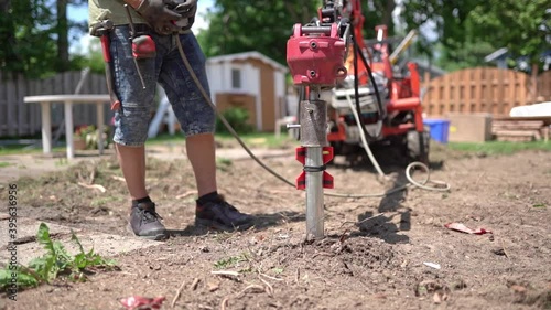 Technician installing foundation helical piles photo