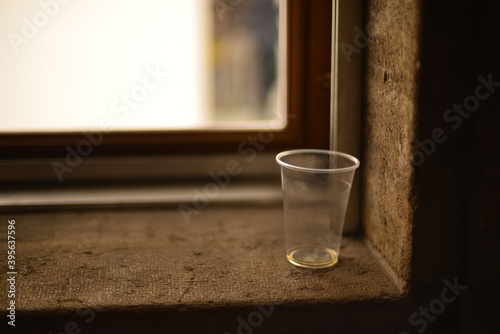 Abandoned empty plastic cup on a window sill
