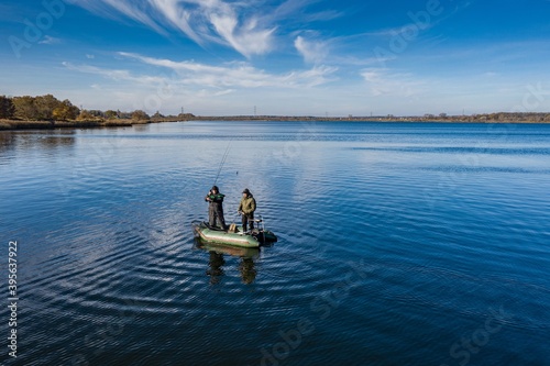 The men in the middle of the lake are fishing on a beautiful autumn day. © Daniel Jędzura
