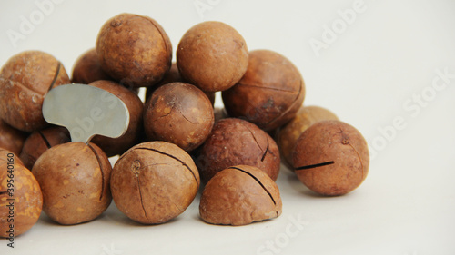 macadamia nuts whole and one split and a metal key on a white background