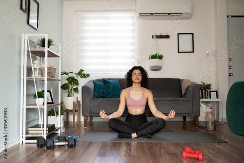 Good-looking female yogi practicing yoga at home